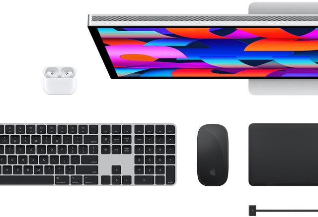 Bovenaanzicht van een aantal Mac-accessoires: Studio Display, Magic Keyboard, Magic Mouse, Magic Trackpad, AirPods en MagSafe-oplaadkabel